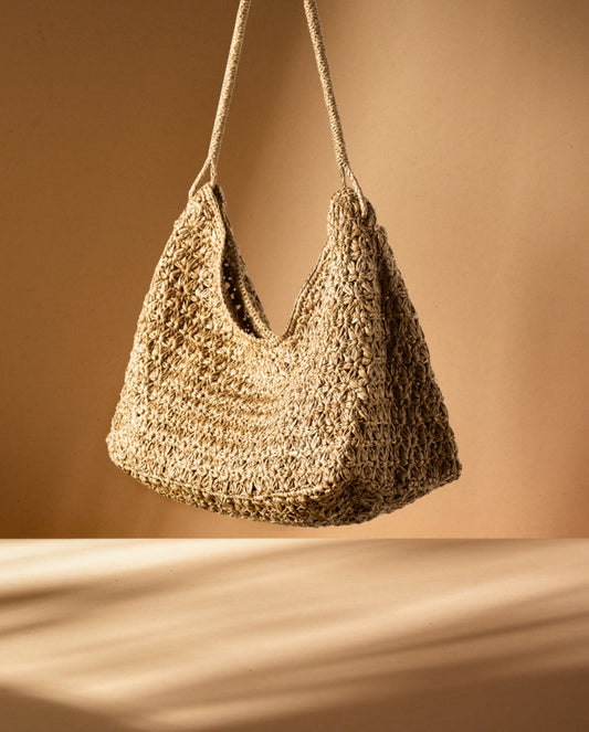 Valiha Bag van Made in Mada in een lichte setting, handgeweven raffia tas met gehaakt patroon – casual chic en tijdloos design