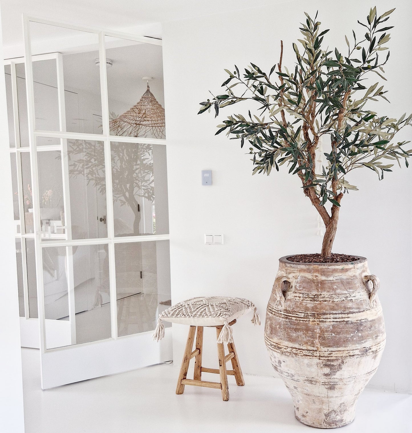 Unieke oude houten Chinese kruk in een wit interieur naast XXXL keramieken pot