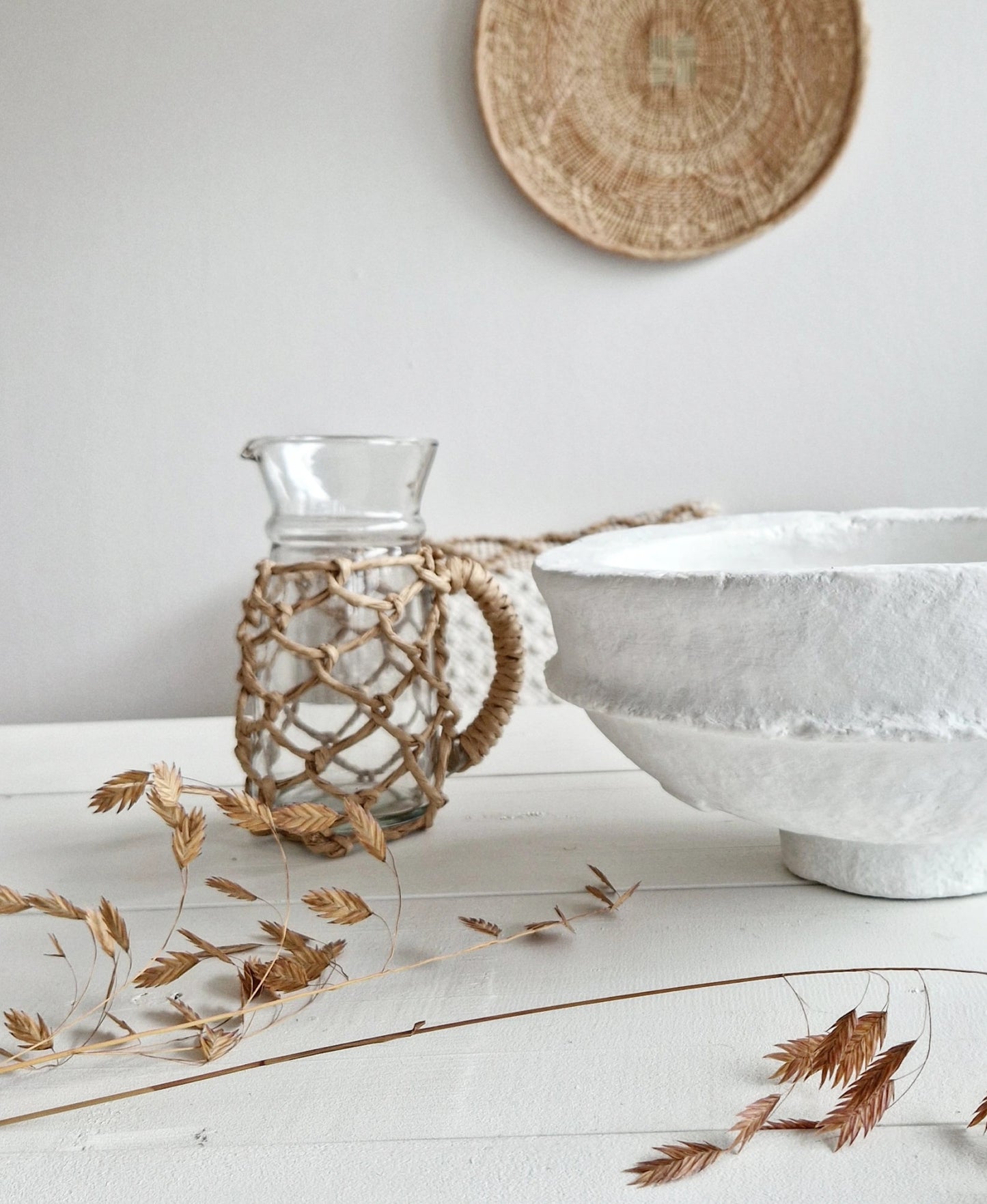 Glass water jug with refined raffia braiding
