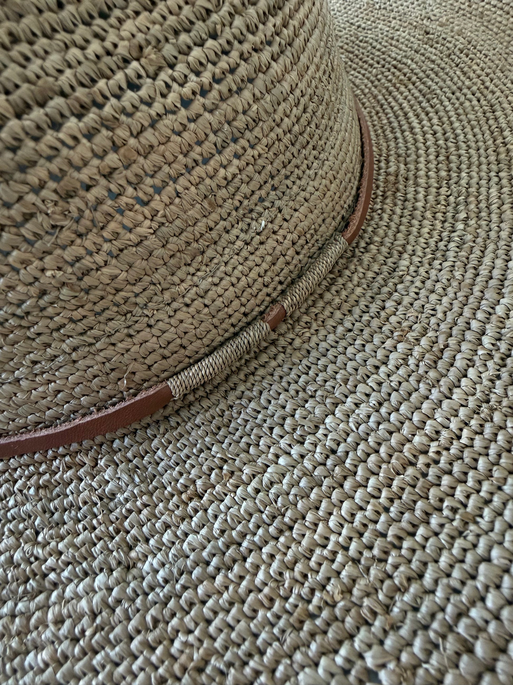 Detail of the Aziz Tan Leather Hat Tea with braided raffia finish and leather cord
