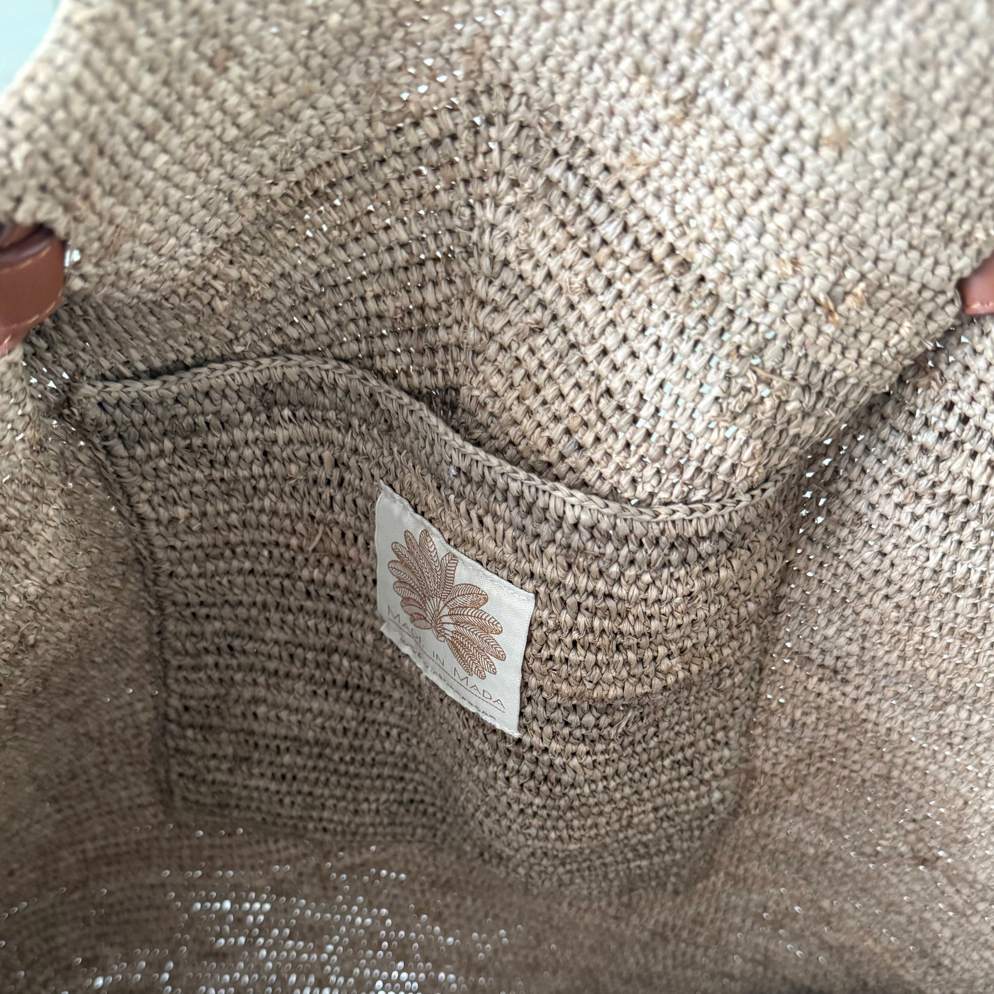 Detail foto van het binnenzakje van de Gemma XXL Bag Tea van Made in Mada van handgeweven raffia met lange leren hengsels