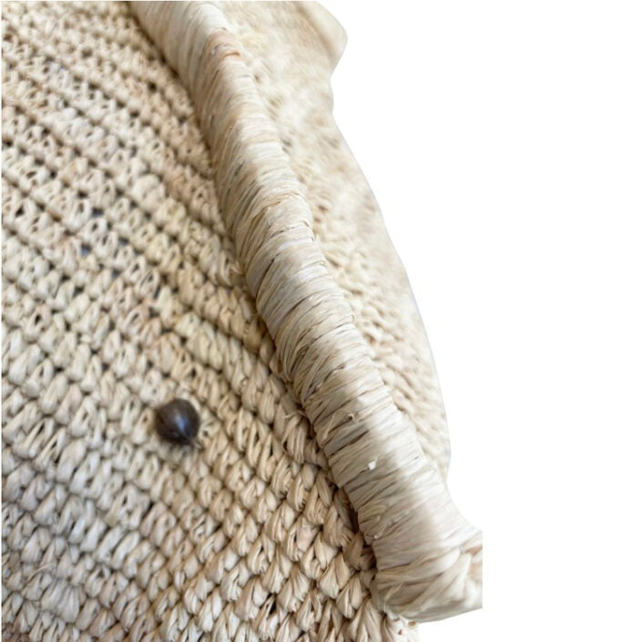 Close-up van de raffiarand en schelp knopje van de Aina M Bag Naturel, toont het fijne handwerk en materiaal