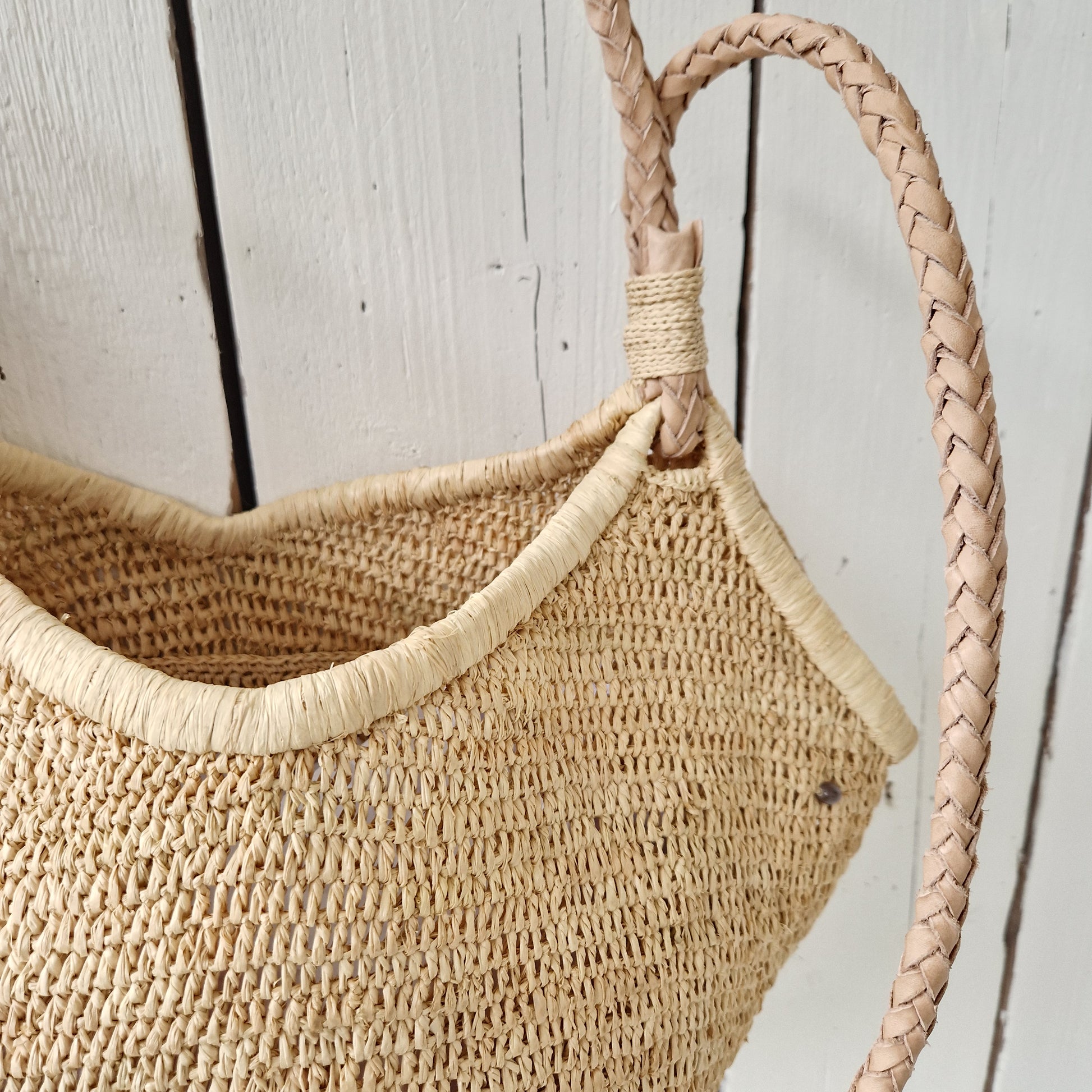 Detail van de lederen hengsels en bovenrand van de Aina M Bag Naturel van Made in Mada, ambachtelijk gevlochten
