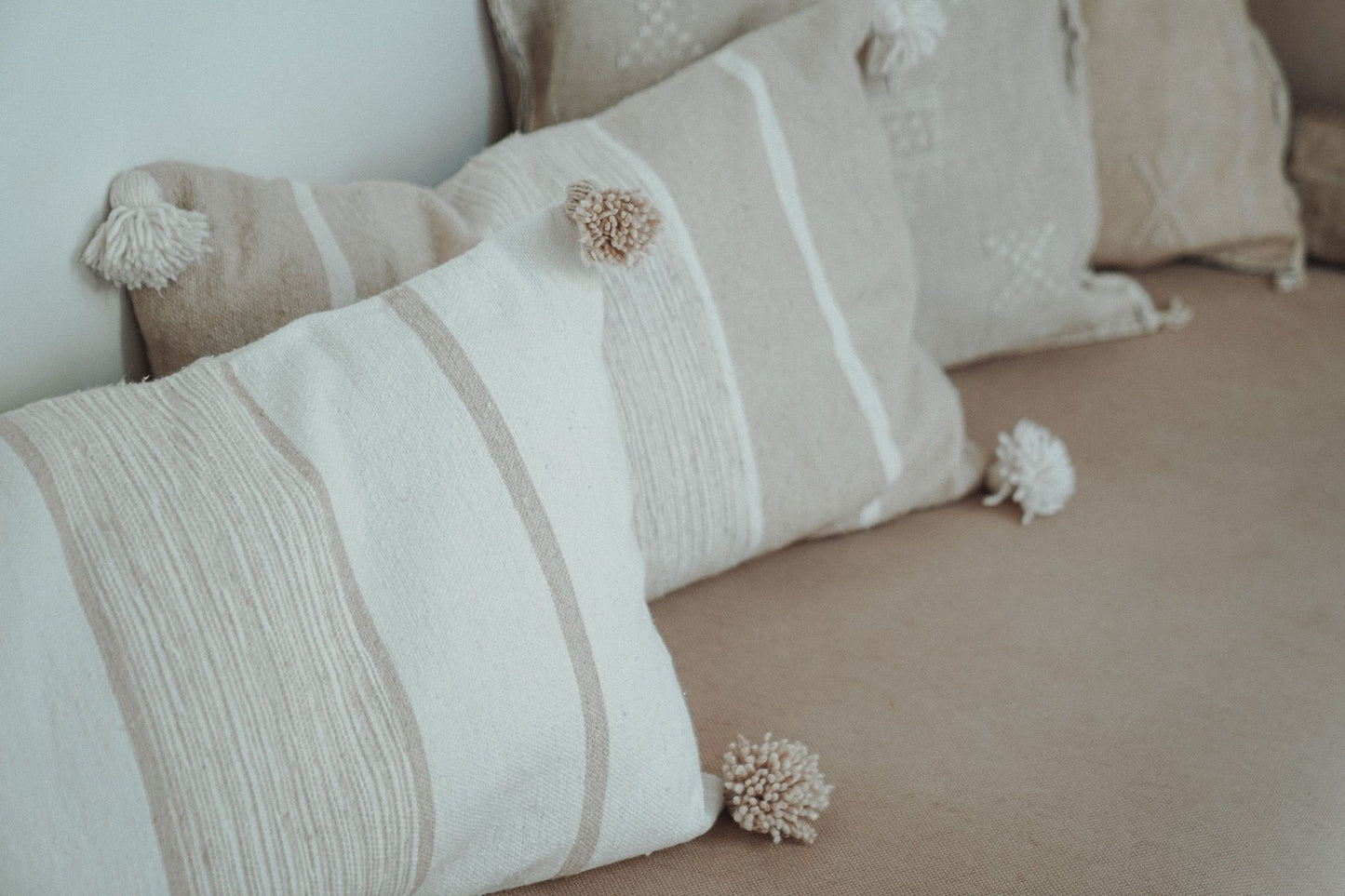 Marokkaans pompom kussen off-white en beige 40x60 op bank