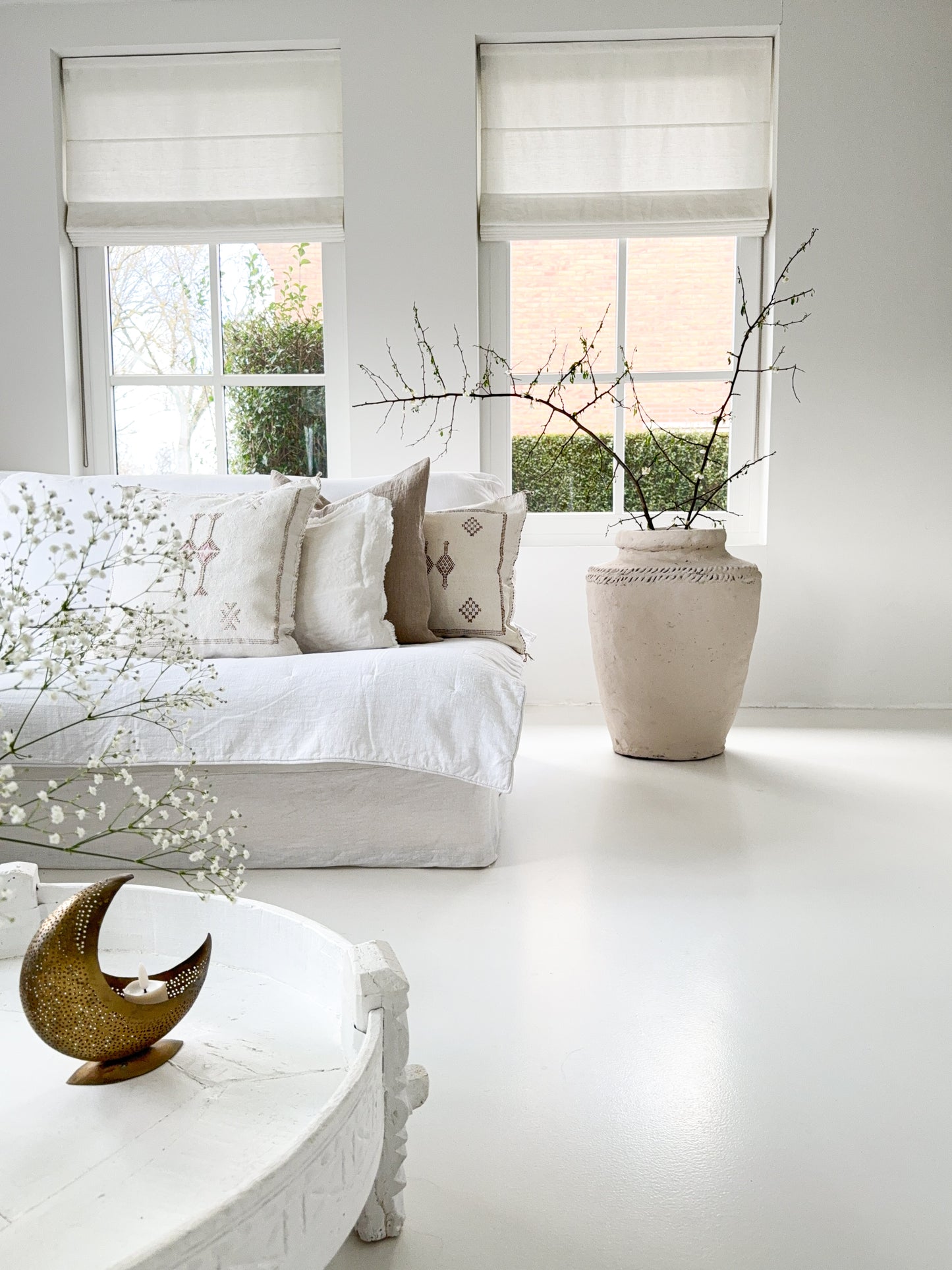XL aardewerk pot in mushroom kleur in een wit interieur naast een linnen bank met linnen en sabra silk kussens.