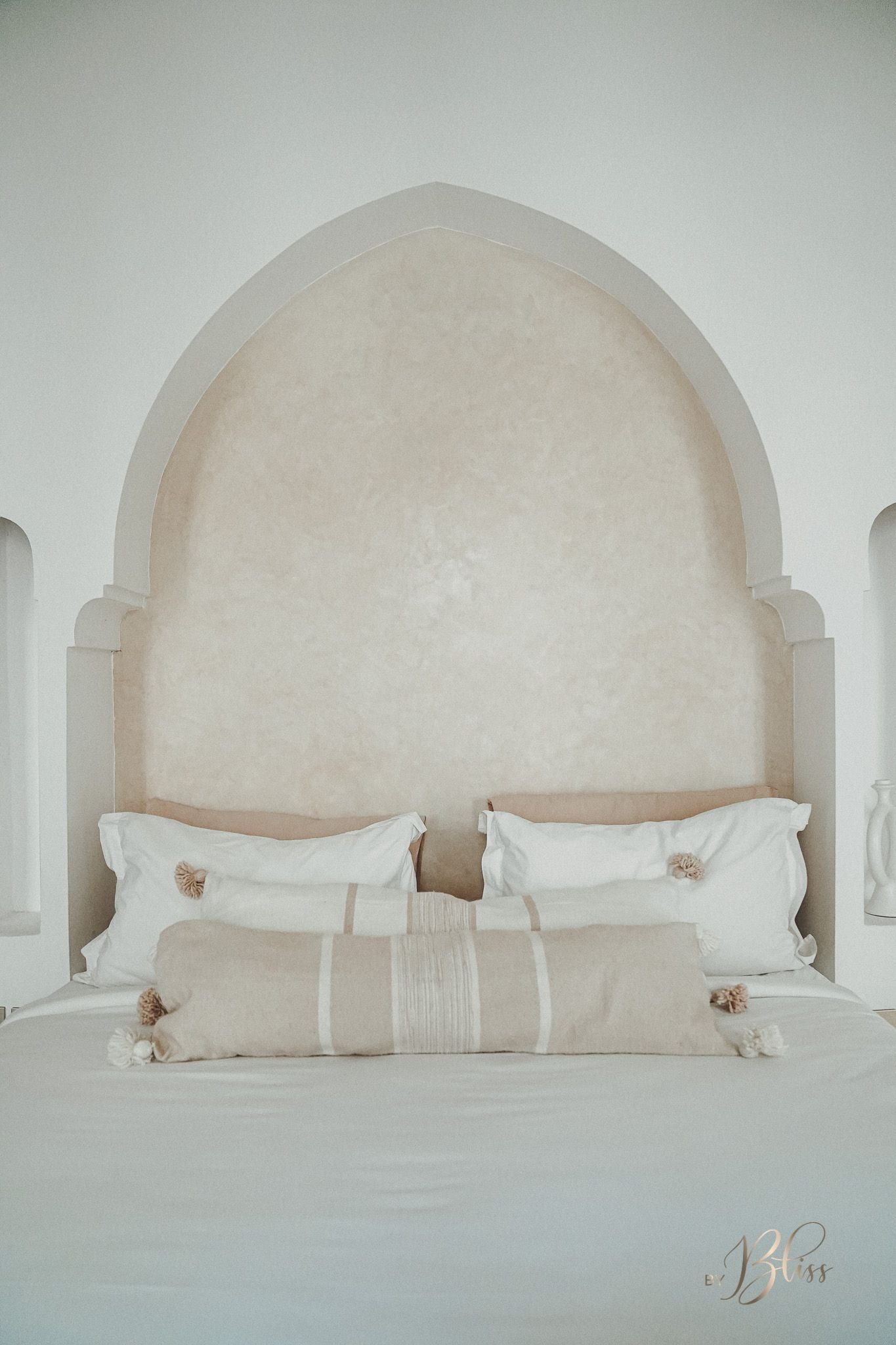 Marokkaanse pompom kussens langwerpig 30x100 beige en off-white op een bed
