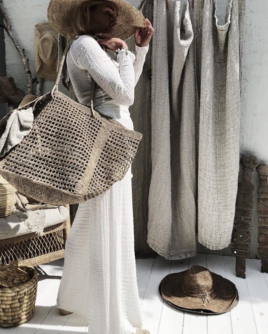 Hit Bag Tea van Made in Mada gedragen als opengewerkte raffia tas