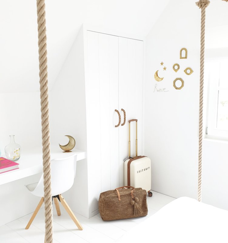 Ivy Bag Tea van Made in Mada raffia weekendtas in lichte slaapkamer naast koffer